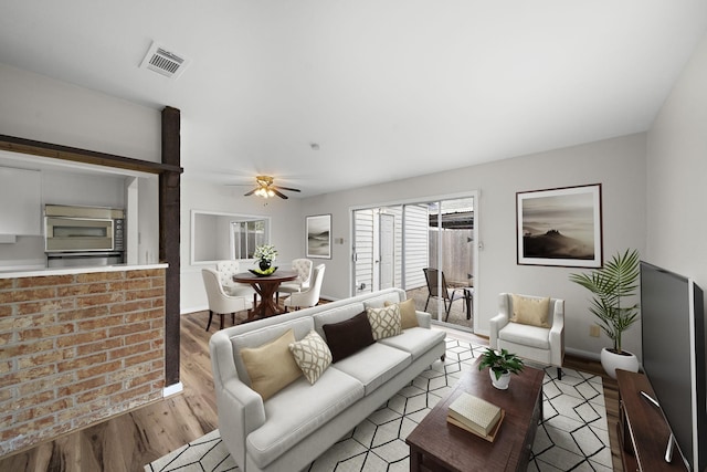 living room with ceiling fan and light wood-type flooring