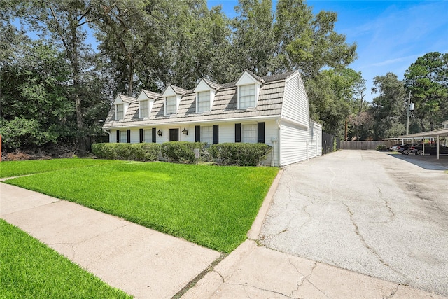 cape cod home with a carport and a front yard