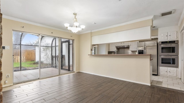 interior space with crown molding and a notable chandelier