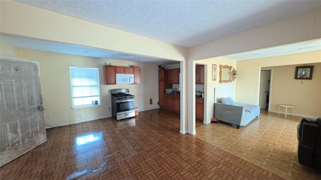 unfurnished living room featuring parquet flooring and a textured ceiling