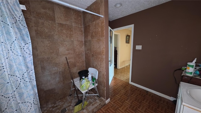 bathroom with vanity, parquet flooring, a textured ceiling, and a shower with shower curtain