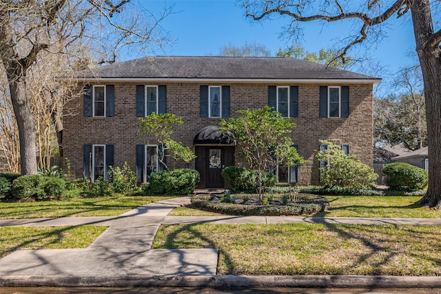 view of front of property featuring a front yard and brick siding