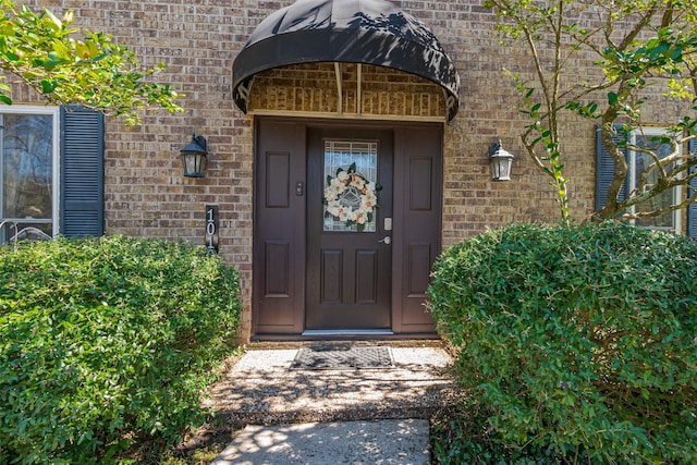 doorway to property with brick siding