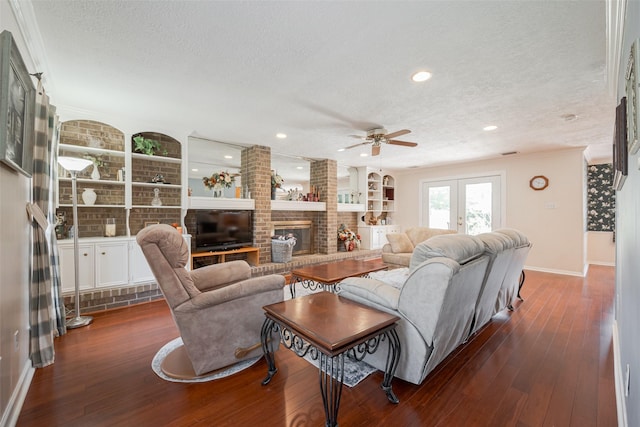 living area featuring a fireplace, dark wood-type flooring, a textured ceiling, and french doors