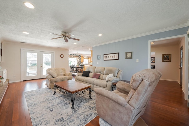 living area featuring a textured ceiling, french doors, ornamental molding, and dark wood finished floors