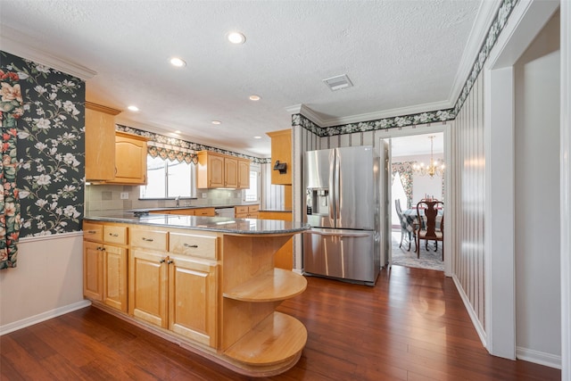 kitchen featuring dark wood finished floors, ornamental molding, a textured ceiling, stainless steel fridge, and a peninsula