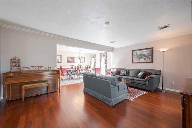 living room with a chandelier, a textured ceiling, visible vents, wood-type flooring, and crown molding