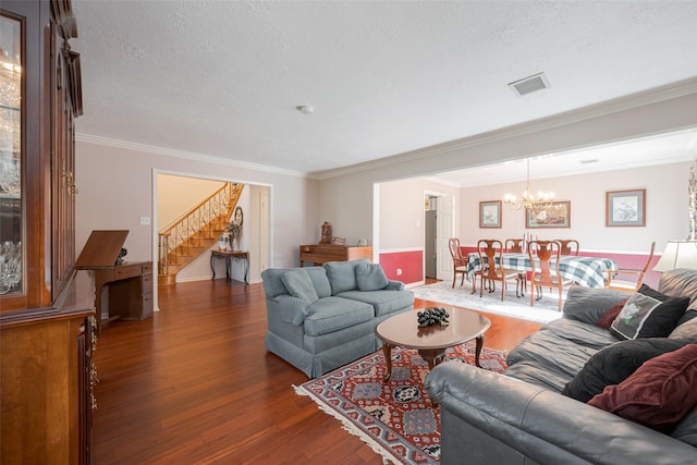 living area with crown molding, a notable chandelier, stairway, a textured ceiling, and wood finished floors