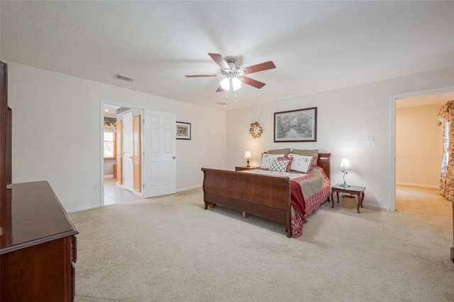 bedroom featuring a textured ceiling, light colored carpet, a ceiling fan, baseboards, and visible vents