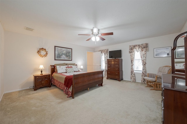 bedroom with light carpet, visible vents, and a ceiling fan