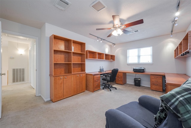 home office with light carpet, attic access, and visible vents