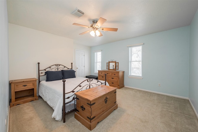 bedroom featuring light carpet, a ceiling fan, visible vents, and baseboards