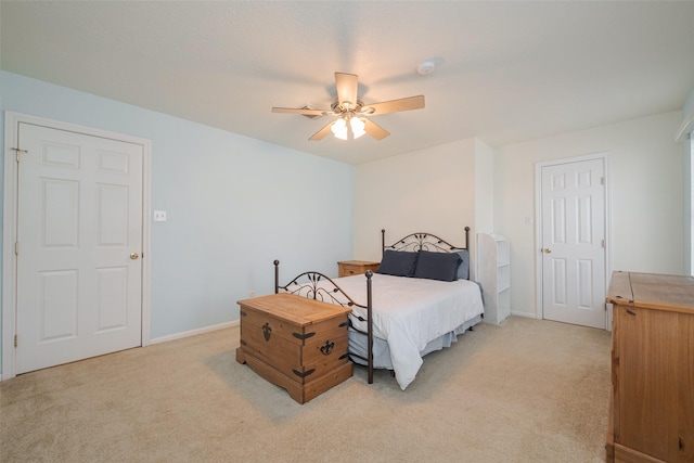 bedroom featuring light carpet, ceiling fan, and baseboards