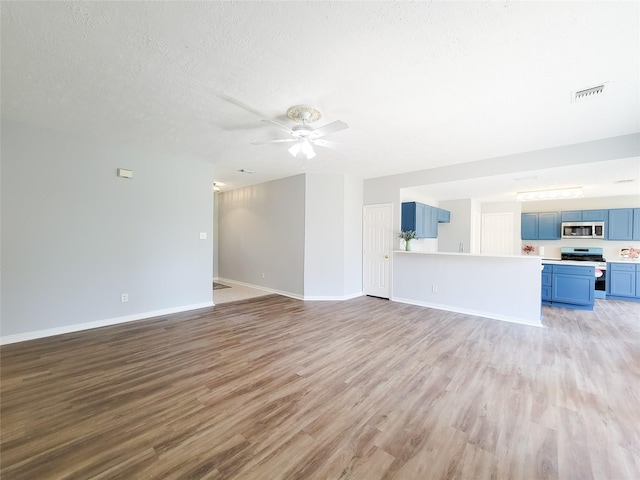 unfurnished living room featuring ceiling fan, a textured ceiling, and light hardwood / wood-style flooring