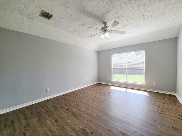 spare room with a textured ceiling, dark wood-type flooring, and ceiling fan