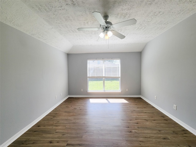 spare room featuring ceiling fan, vaulted ceiling, dark hardwood / wood-style floors, and a textured ceiling