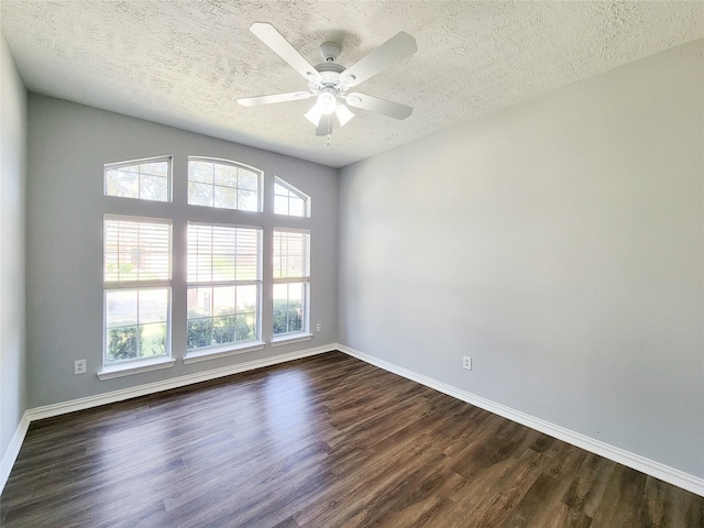 spare room with a textured ceiling, dark wood-type flooring, and ceiling fan