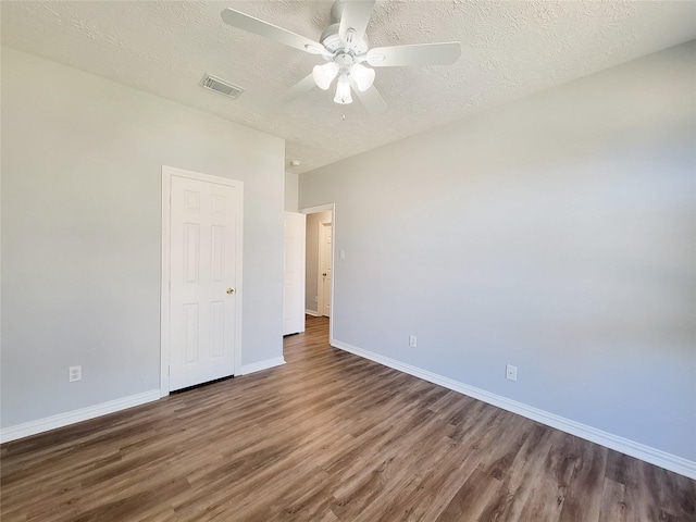 unfurnished bedroom with ceiling fan, dark wood-type flooring, and a textured ceiling