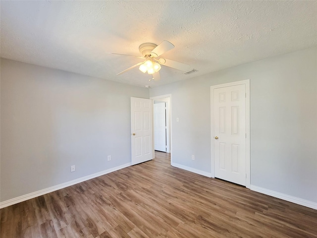 unfurnished bedroom featuring hardwood / wood-style flooring, ceiling fan, and a textured ceiling