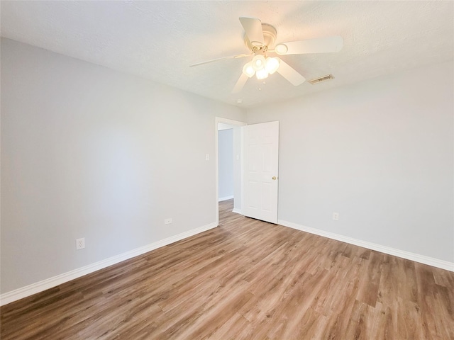 unfurnished room with ceiling fan, light hardwood / wood-style flooring, and a textured ceiling