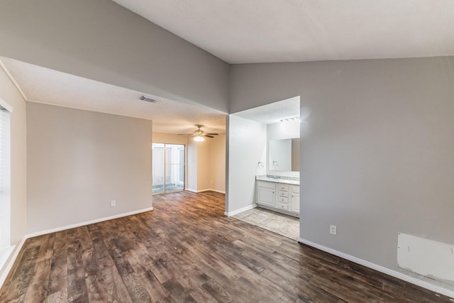 empty room featuring lofted ceiling, dark hardwood / wood-style floors, and ceiling fan