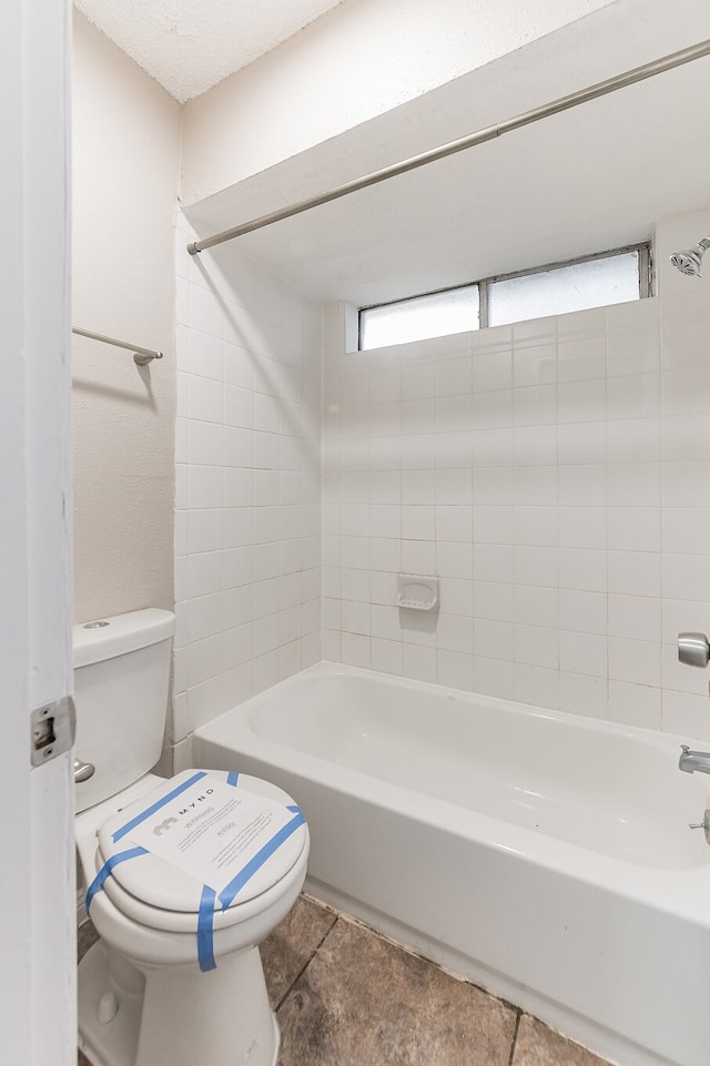 bathroom with tiled shower / bath and toilet