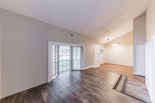 empty room featuring hardwood / wood-style floors and high vaulted ceiling