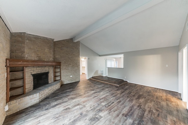 unfurnished living room featuring wood-type flooring, lofted ceiling with beams, and a brick fireplace