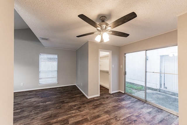 unfurnished room with ceiling fan, dark hardwood / wood-style floors, and a textured ceiling