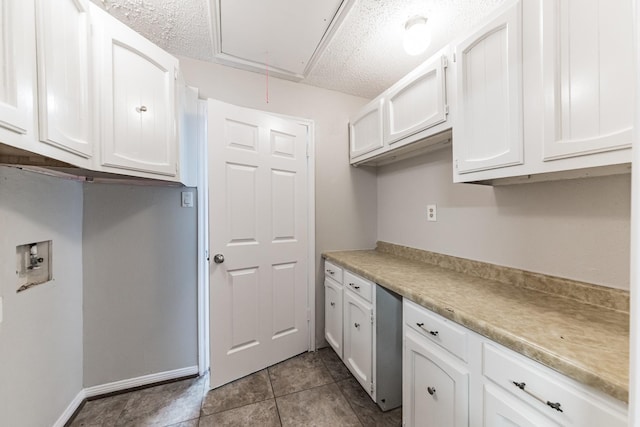 kitchen featuring light tile patterned floors, a textured ceiling, and white cabinets