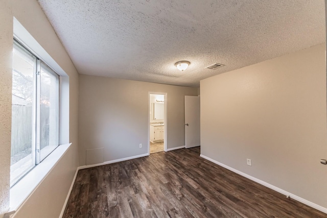 unfurnished room with dark hardwood / wood-style floors and a textured ceiling