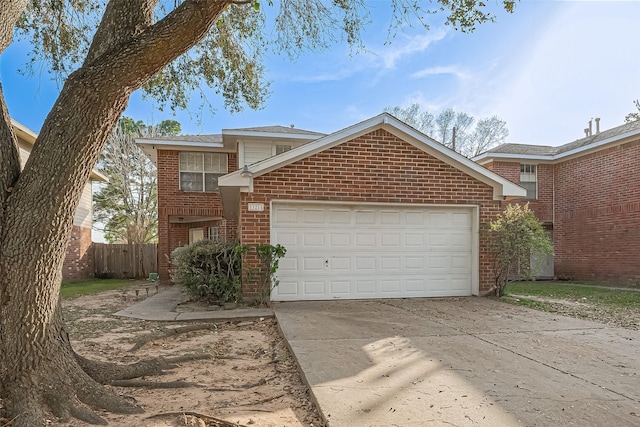 traditional-style house featuring an attached garage, fence, brick siding, and driveway