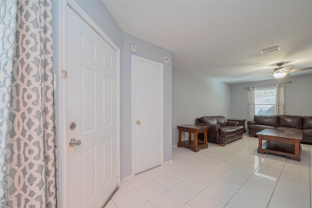 living area with light tile patterned flooring, visible vents, and ceiling fan