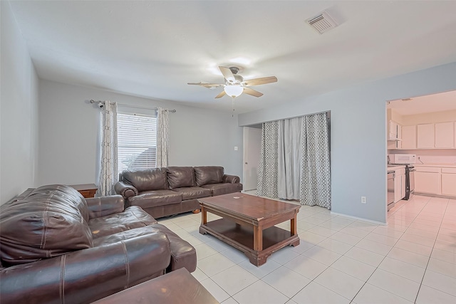 living area with light tile patterned floors, a ceiling fan, and visible vents