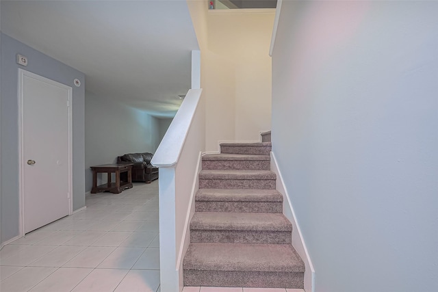 stairway with tile patterned floors and baseboards