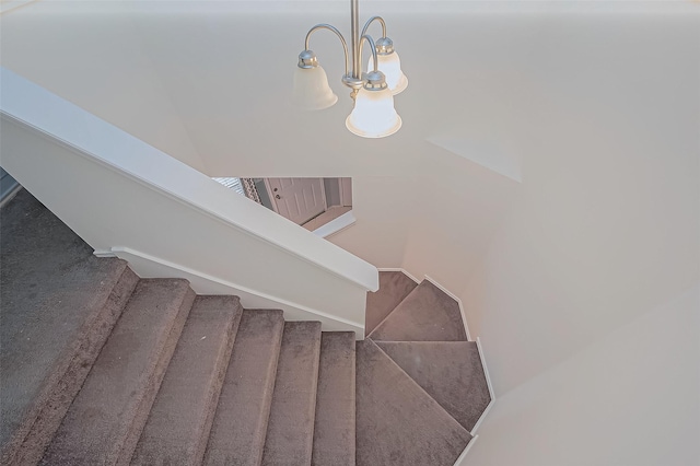 stairs with a chandelier