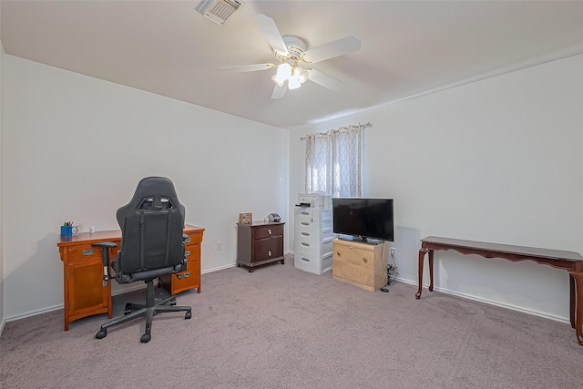 office area with light colored carpet, a ceiling fan, visible vents, and baseboards