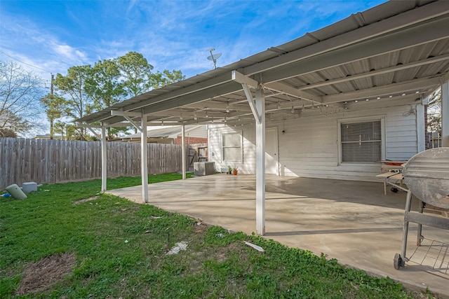 view of patio with an attached carport, central AC, and fence