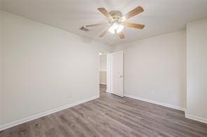 unfurnished room with dark wood-type flooring and ceiling fan