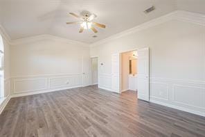 interior space with vaulted ceiling, dark wood-type flooring, ceiling fan, and crown molding