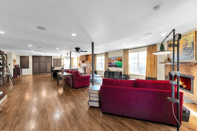 living area with a fireplace, visible vents, dark wood finished floors, and recessed lighting