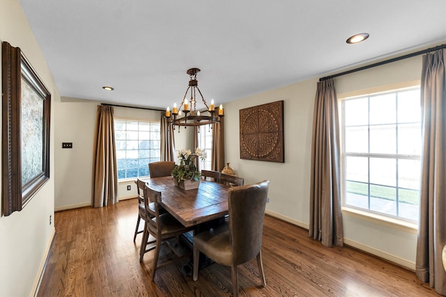 dining area featuring a notable chandelier, baseboards, wood finished floors, and recessed lighting