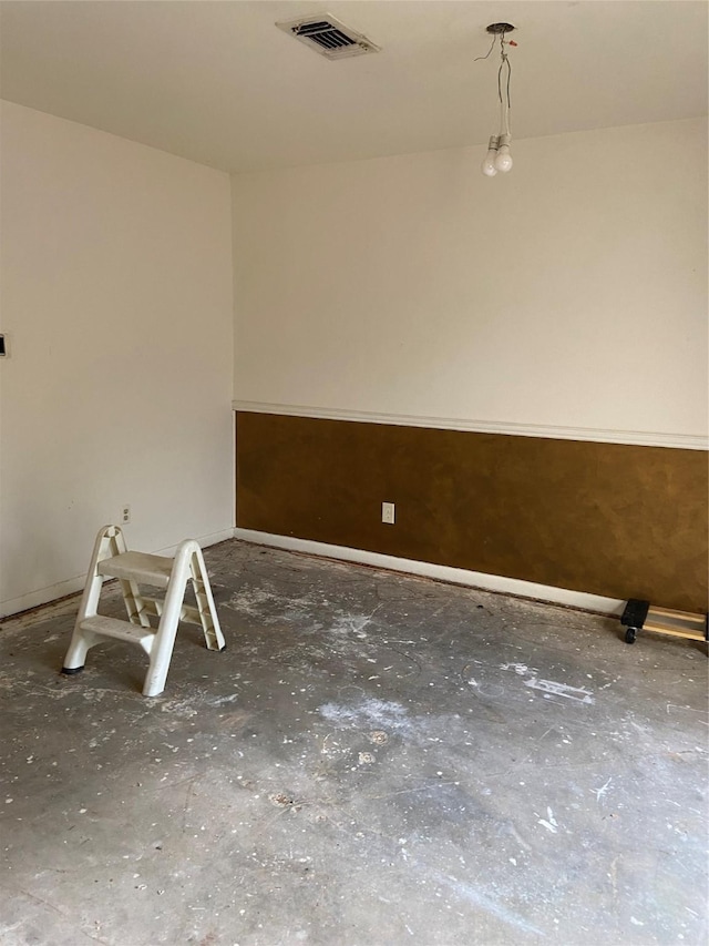 spare room featuring concrete floors and visible vents