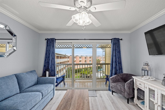 living room with ornamental molding, a textured ceiling, and light wood-type flooring