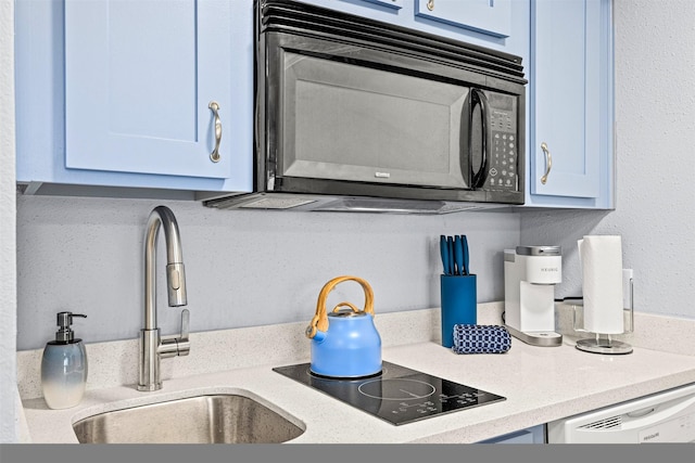 kitchen featuring sink, black appliances, and blue cabinets