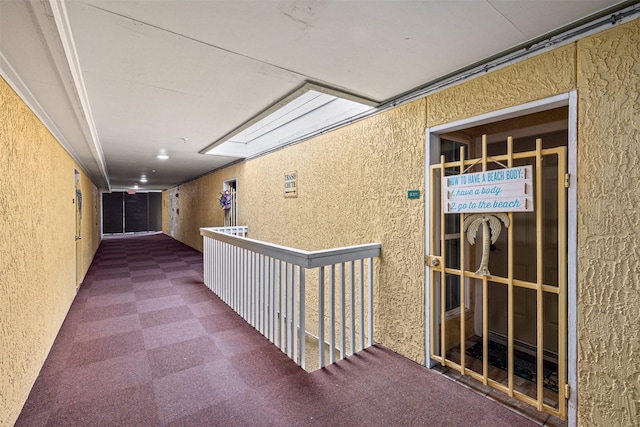 corridor with a skylight and carpet