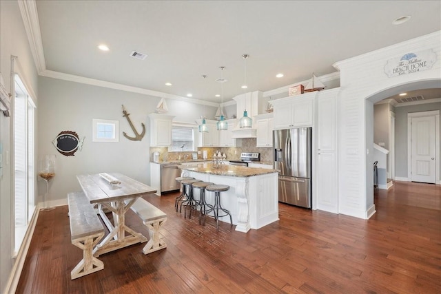 2904 Shady Ln, Crystal Beach, TX 77650 - kitchen with a kitchen island, decorative light fixtures, white cabinets, light stone counters, and stainless steel appliances