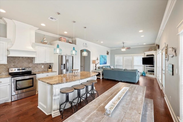 2904 Shady Ln, Crystal Beach, TX 77650 - kitchen with premium range hood, appliances with stainless steel finishes, a center island, light stone countertops, and white cabinets