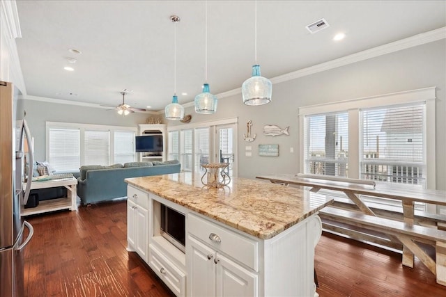 2904 Shady Ln, Crystal Beach, TX 77650 - kitchen featuring white cabinetry, a center island, hanging light fixtures, dark hardwood / wood-style floors, and stainless steel fridge