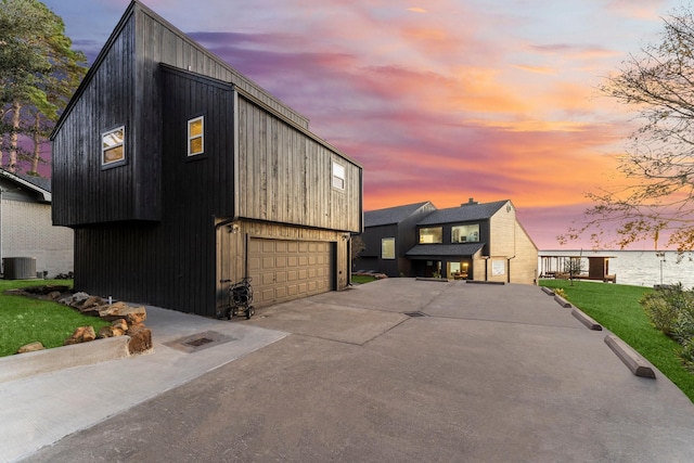 view of front of property with a garage, cooling unit, and a lawn